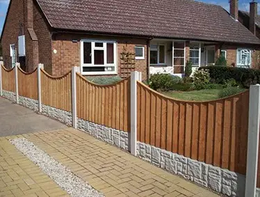 Concave-top fence panels on concrete posts and gravel boards along a front garden