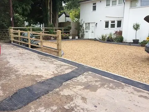 Post-and-rail timber fence beside a new gravel driveway