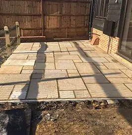 New closeboard fence behind a freshly laid sandstone patio in Guildford