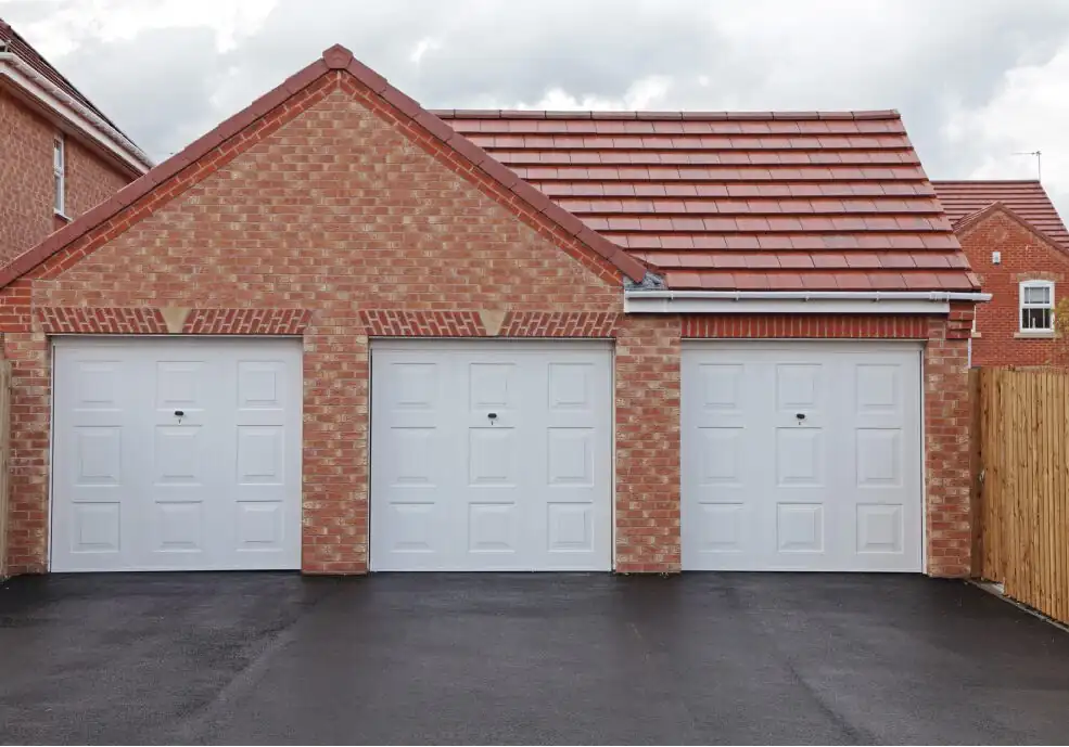 Freshly surfaced driveway in front of a brick-built triple garage